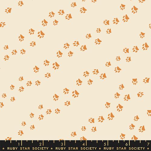 Diagonal trails of paw prints that track across an eggshell background. From the Dog Park Collection by Ruby Star for Moda Fabrics. 100% Cotton, 44/45" wide.