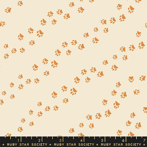 Diagonal trails of paw prints that track across an eggshell background. From the Dog Park Collection by Ruby Star for Moda Fabrics. 100% Cotton, 44/45" wide.