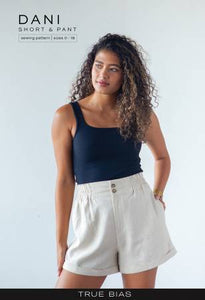 The Dani pattern is an elastic waist short or pant with inseam and rear pockets, a small paperbag waist, and a cuff. Views A and C are shorts with an approximate 3 inch inseam. Views B and D are pants that hit at the ankle with an approximate 27.5 inch inseam. Views A and B have a zip fly and two buttons at the waist, while Views C and D have a full elastic waistband for an easy pull on fit.