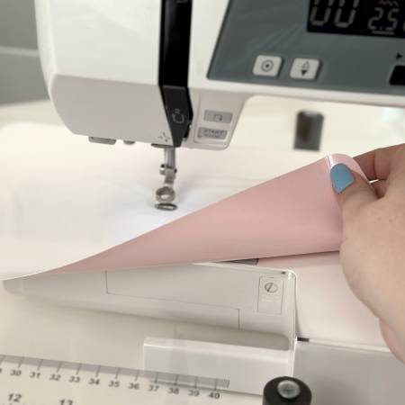The Supreme Slider from The Gypsy Quilter® was developed by award-winning quilter Pat LaPierre to make free-motion quilting a breeze on your domestic sewing machine. The pink sticky back grips the bed or your machine and keeps the slider from shifting while you work. 