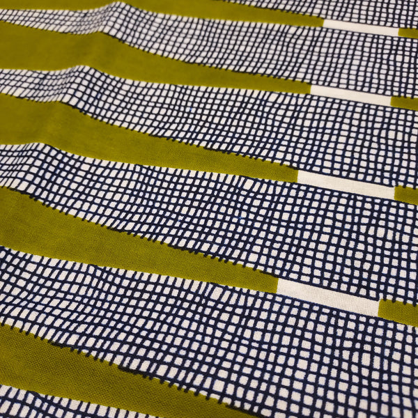 Vibrant olive green with navy cross hatch on a white background. This heavier cotton is a perfect fabric for bottom weight garments, bags, or housewares. This rich olive green is absolutely stunning in person. Triangle design