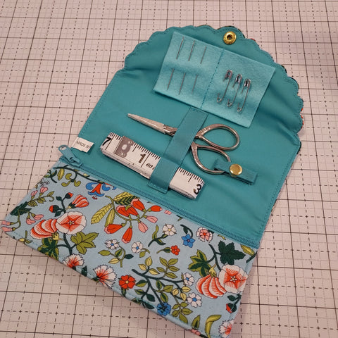 The Liberty Fabrics Sewing Roll allows you to carry your most trusted sewing tools with you anywhere you go. The sewing basket comes in a variety of Liberty Fabrics prints and includes 1 embroidery scissors, 1 tape measure, 3 safety pins, and 3 needles. It also has a zip pocket for other items. Spot clean only. Approximate size is 3in x 6.75in closed and 9.5in open.   