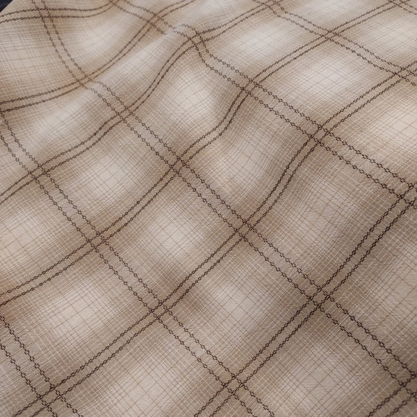 This beautiful woven fabric is made in Japan. Featuring a textured weave, this plaid is beige, cream and brown. Could quality for top or bottom weight. 