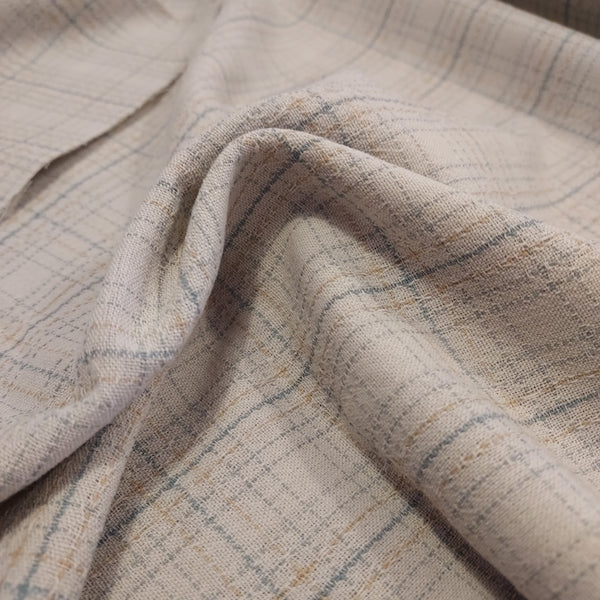 This beautiful woven fabric is made in Japan. Featuring a textured weave, this plaid is cream with light blue lines throughout. Suitable top or bottom weight. 100% Cotton, 44" wide.