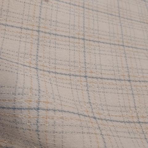 This beautiful woven fabric is made in Japan. Featuring a textured weave, this plaid is cream with light blue lines throughout. Suitable top or bottom weight. 100% Cotton, 44" wide.