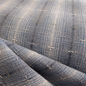 This beautiful woven fabric is made in Japan. Featuring a textured weave, this plaid is blue with navy blue and beige lines throughout. Suitable top or bottom weight. 100% Cotton, 44" wide.