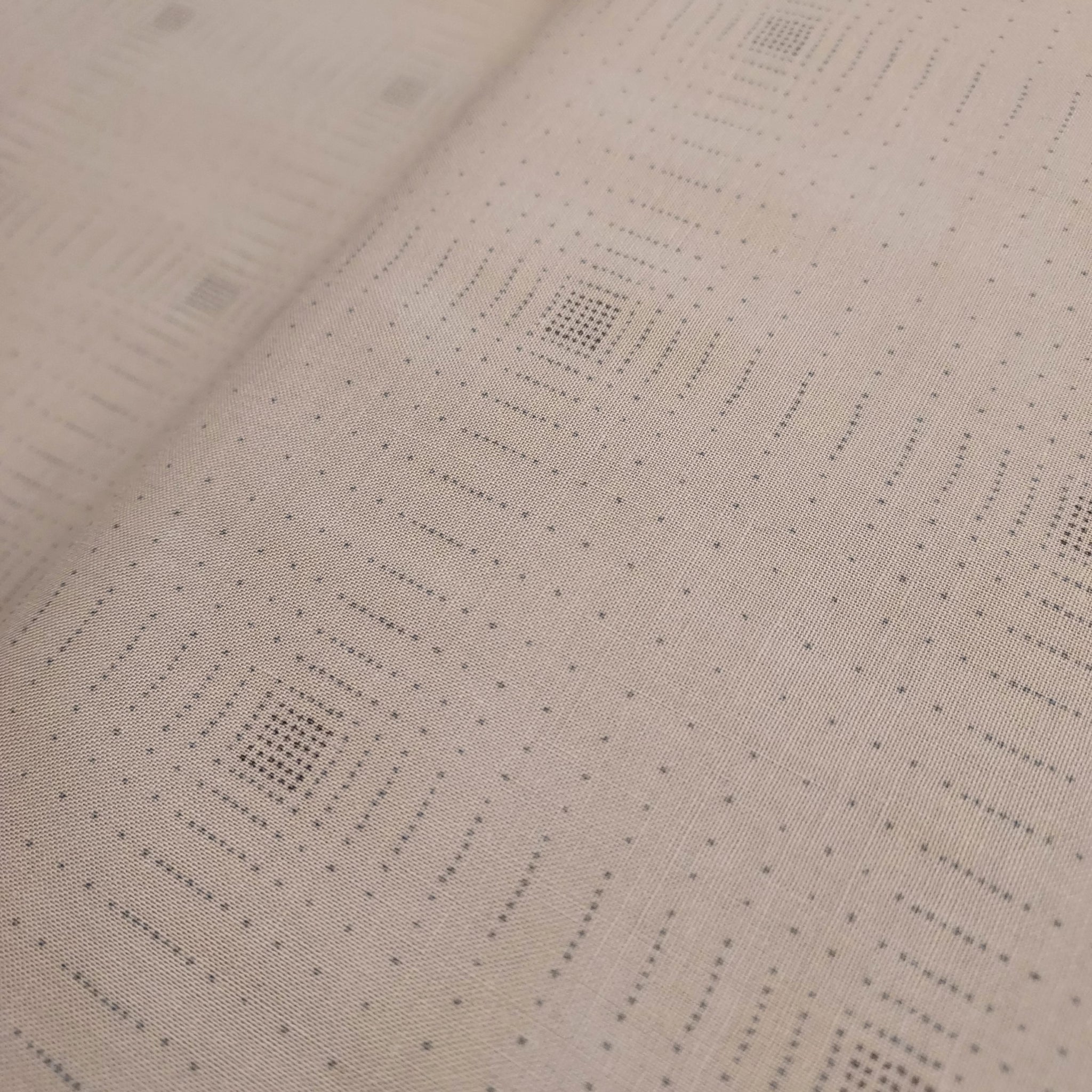 This beautiful cotton fabric is made in Japan. Soft hand and lightweight feel, this fabric has dark brown dots all over the fabric that form a grid. These dots are in a square cluster and disperse throughout. The tiny dots are over a taupe background. This fabric is beautiful and would be suitable for quilting or apparel sewing. 