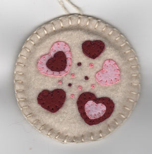 Our candle mat kits are in the style of penny rugs from the early 1800’s. These measure 83⁄4″ diameter and are two layers thick with 7⁄8″ and 11⁄2″ penny appliqués.  Everything you need to start is right in the package including all cut wool felt, floss, a needle and instructions.