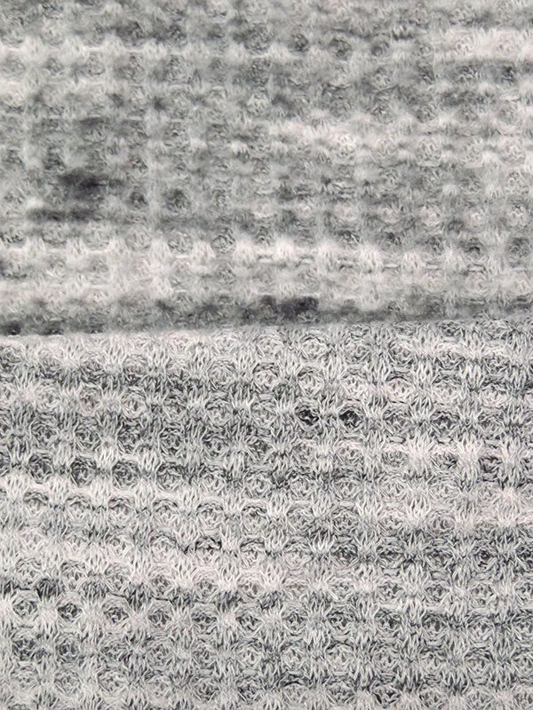 ﻿This is a heathered brushed sweater knit that is 60" wide. It is a polyester and lycra blend. The color is a heathered grey and black with some lighter grey. It has a 4 way stretch that is 70% selvage to selvage. Fuzzy hand which makes it super cozy. 