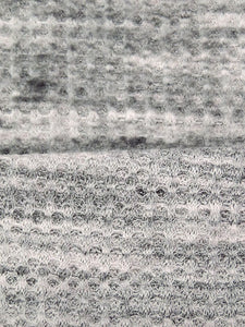 ﻿This is a heathered brushed sweater knit that is 60" wide. It is a polyester and lycra blend. The color is a heathered grey and black with some lighter grey. It has a 4 way stretch that is 70% selvage to selvage. Fuzzy hand which makes it super cozy. 