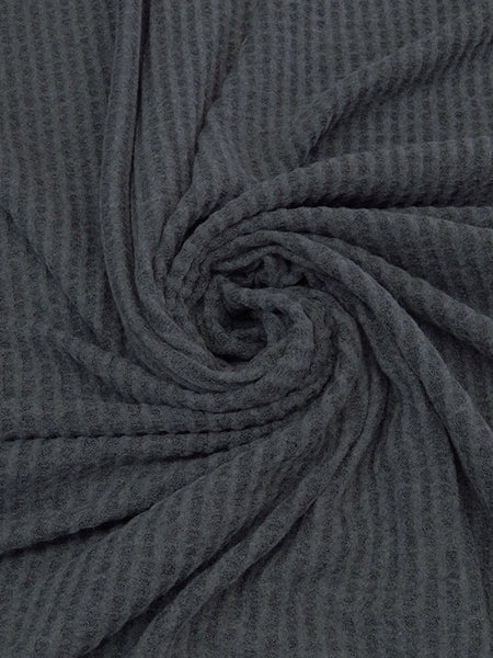 ﻿This sweater knit is a heathered brushed waffle. Super soft fabric that has a decent thickness. This fabric is 50" wide and is a polyester, rayon, lycra blend. It also has a 4 way stretch that is 50% selvage to selvage. This fabric would make the comfiest lounge set! 