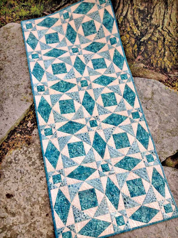 The center Snail's Trail block is created with two different sizes of blocks using the Creative Grids Square on Square Trim Tool for 3 and 6-inch blocks. The siinch blocks make the center and the three-inch blocks make the cornerposts. The diamonds are simply paper-pieced. And, since everything is trimmed to size after cutting sewing and pressing, all of those units go together like a dream!