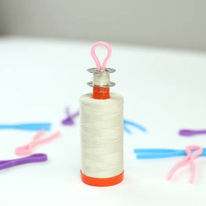Bobbin Buddies bobbin clips keep your bobbin and matching thread together. Works for most thread spools and bobbins. Squeeze the ends together, slide on bobbin and thread spool. 