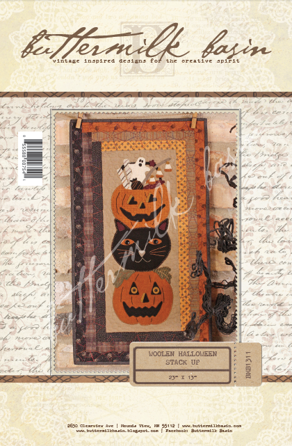 This whimsical trio of two pumpkins and a black cat stacked are happily waiting to greet trick-or-treaters. Pattern includes directions for piecing and wool appliqué.  Finished size: 24" x 13"