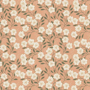  This beautiful fabric is covered in delicate white flowers with little green leaves. The background is a peachy orange, and the flowers have yellow and gold lines on each petal. 